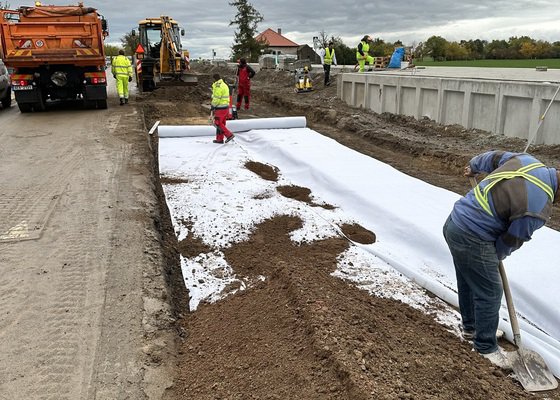 Vlaková zastávka a parkovací stání s chodníkem